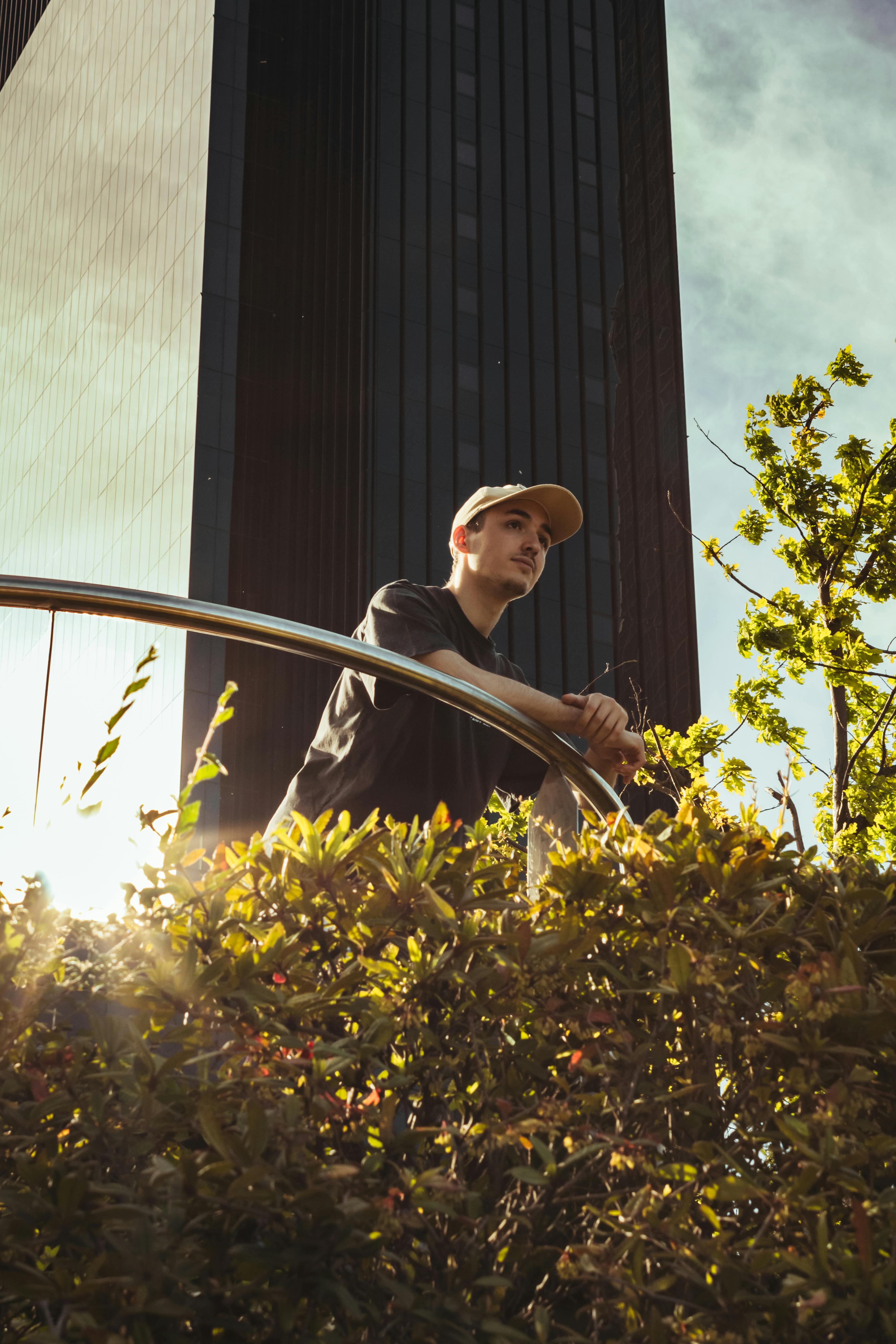 A person pausing among greenery in an urban setting